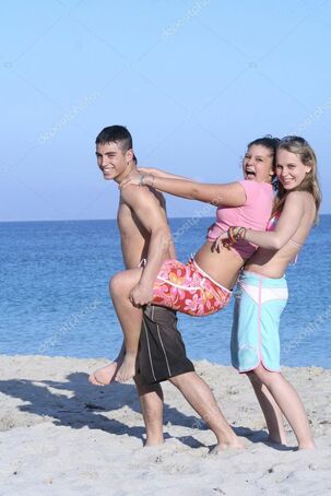 Kids goofing on beach on summer vacation or spring, break -