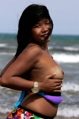 Ethnic damsel posing nude on the river beach